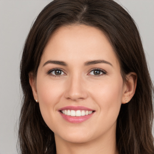 Joyful white young-adult female with long  brown hair and brown eyes