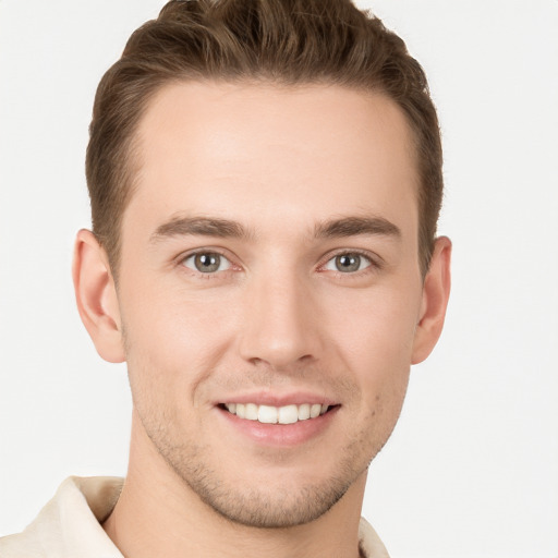 Joyful white young-adult male with short  brown hair and grey eyes