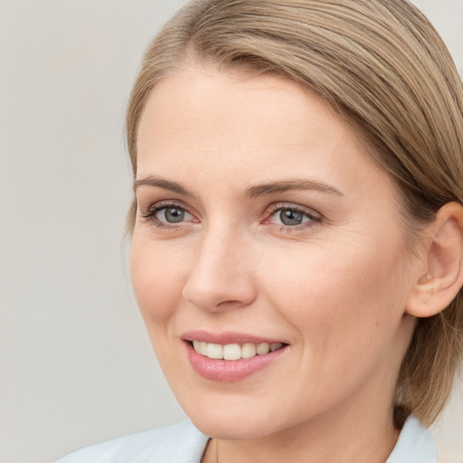 Joyful white young-adult female with medium  brown hair and blue eyes