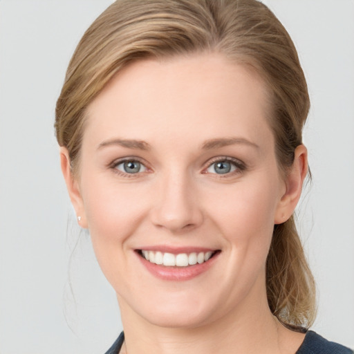 Joyful white young-adult female with medium  brown hair and blue eyes