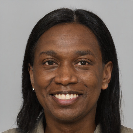 Joyful black young-adult male with long  black hair and brown eyes