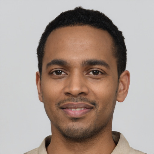 Joyful black young-adult male with short  black hair and brown eyes