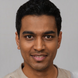 Joyful black young-adult male with short  black hair and brown eyes