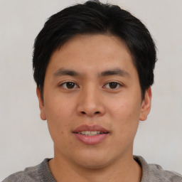 Joyful asian young-adult male with short  brown hair and brown eyes