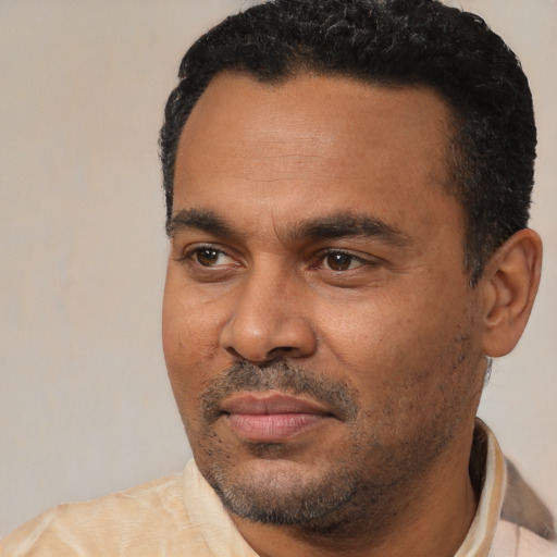 Joyful latino adult male with short  black hair and brown eyes