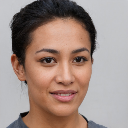 Joyful latino young-adult female with short  brown hair and brown eyes