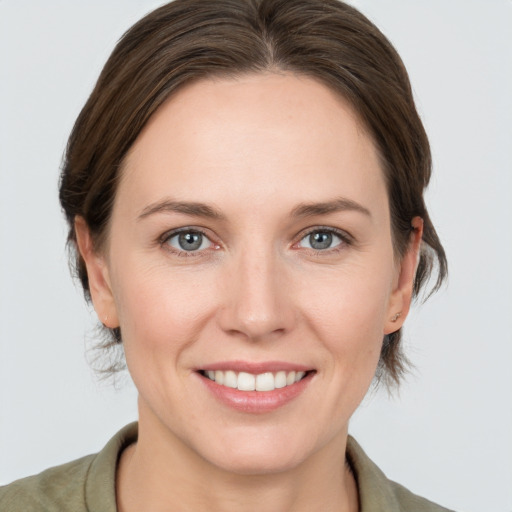 Joyful white young-adult female with medium  brown hair and grey eyes