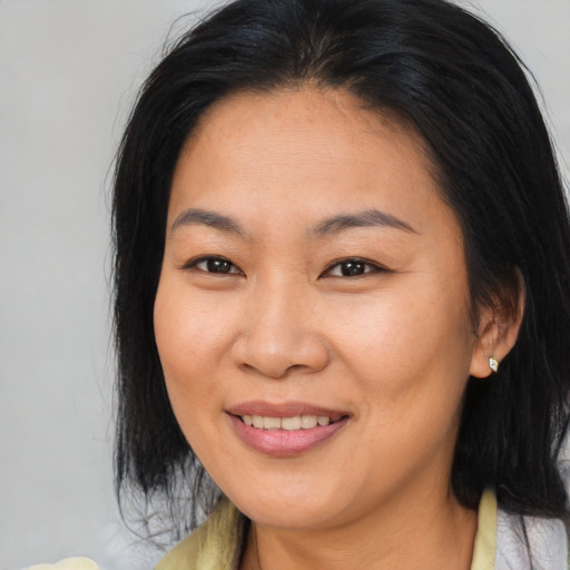 Joyful asian young-adult female with medium  brown hair and brown eyes