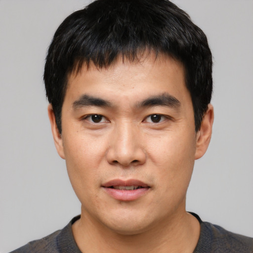 Joyful asian young-adult male with short  black hair and brown eyes