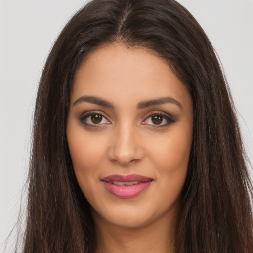 Joyful latino young-adult female with long  brown hair and brown eyes