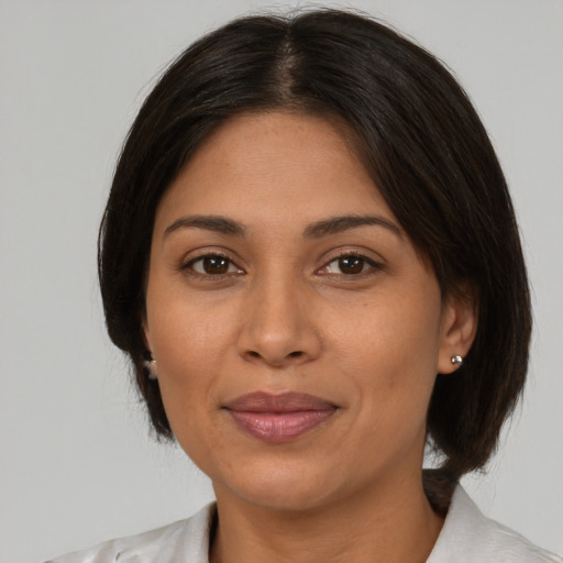 Joyful latino adult female with medium  brown hair and brown eyes