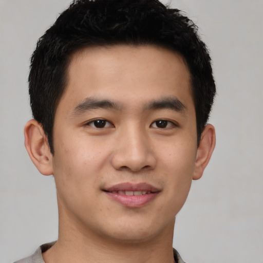 Joyful asian young-adult male with short  black hair and brown eyes