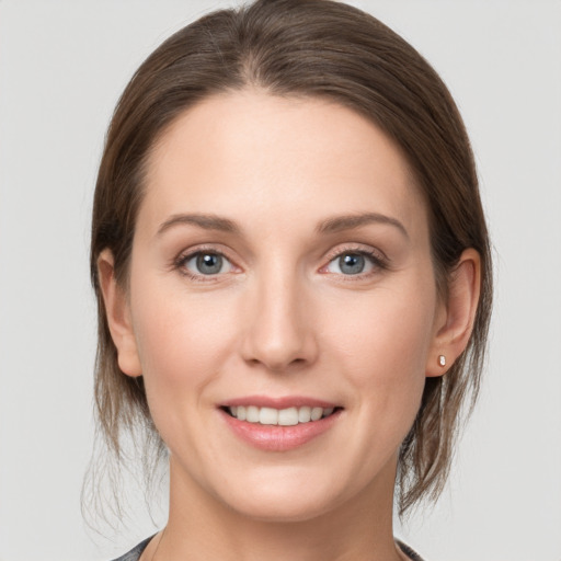 Joyful white young-adult female with medium  brown hair and grey eyes