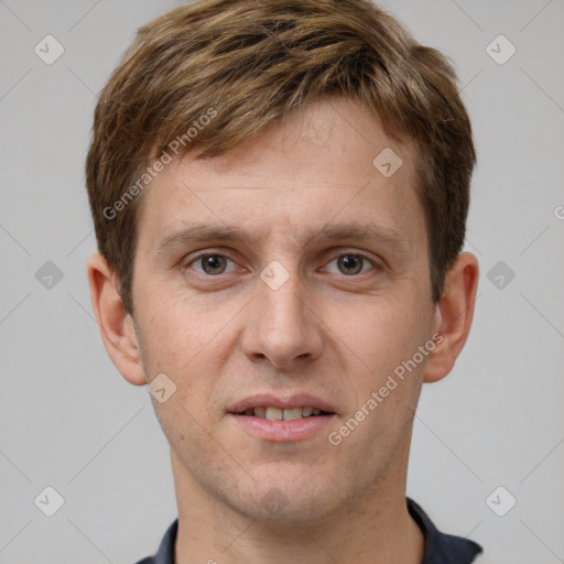 Joyful white young-adult male with short  brown hair and grey eyes