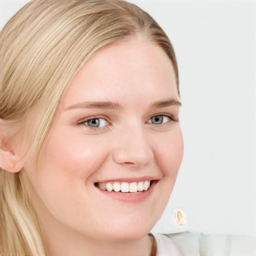 Joyful white young-adult female with long  blond hair and blue eyes