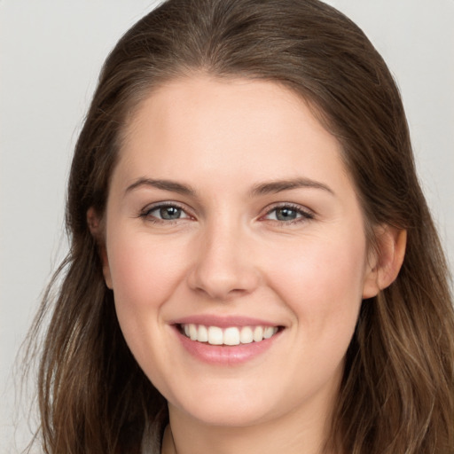 Joyful white young-adult female with long  brown hair and grey eyes