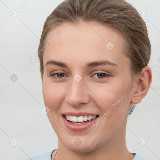 Joyful white young-adult female with short  brown hair and grey eyes