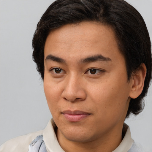 Joyful latino young-adult male with short  brown hair and brown eyes
