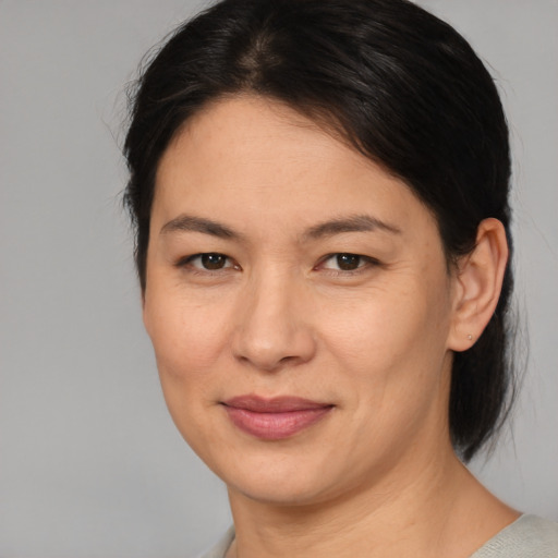 Joyful asian adult female with medium  brown hair and brown eyes