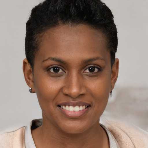Joyful black young-adult female with short  brown hair and brown eyes