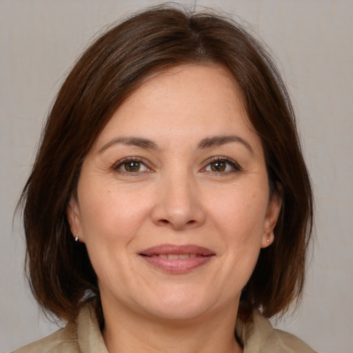 Joyful white adult female with medium  brown hair and brown eyes