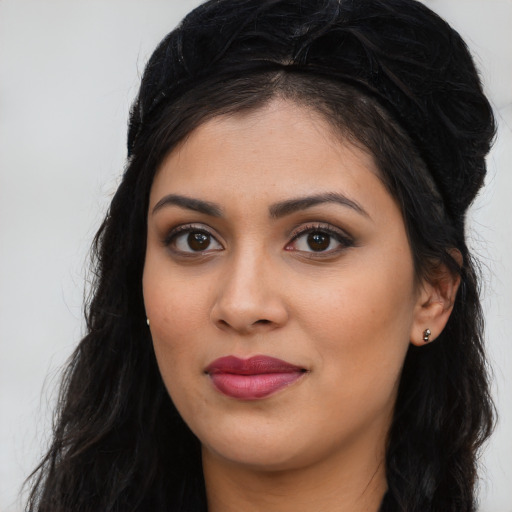 Joyful latino young-adult female with long  black hair and brown eyes