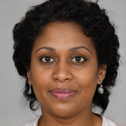 Joyful black adult female with long  brown hair and brown eyes
