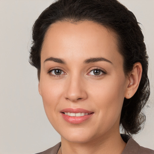 Joyful white young-adult female with long  brown hair and brown eyes