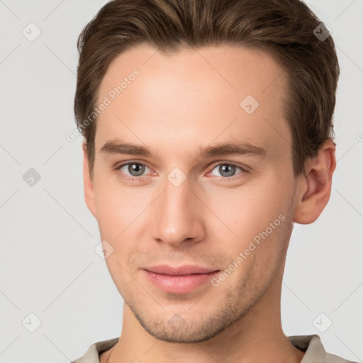 Joyful white young-adult male with short  brown hair and grey eyes