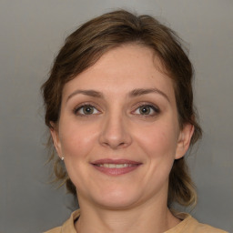 Joyful white adult female with medium  brown hair and grey eyes