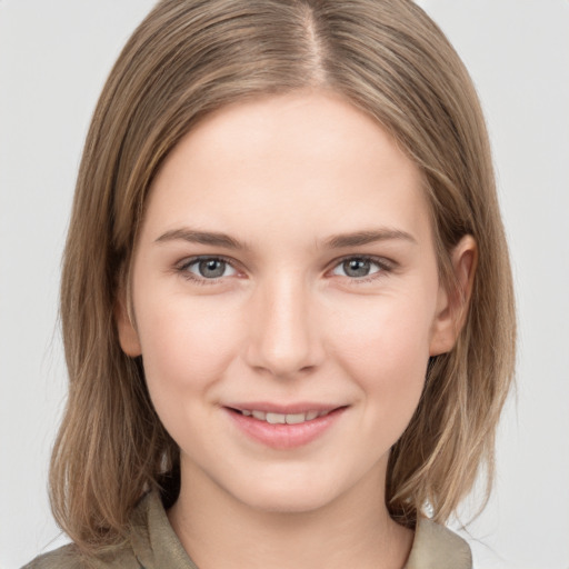 Joyful white young-adult female with medium  brown hair and grey eyes