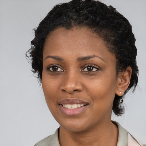 Joyful black young-adult female with medium  black hair and brown eyes