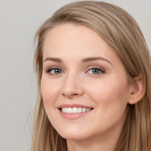 Joyful white young-adult female with long  brown hair and blue eyes