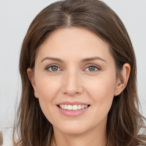 Joyful white young-adult female with long  brown hair and brown eyes