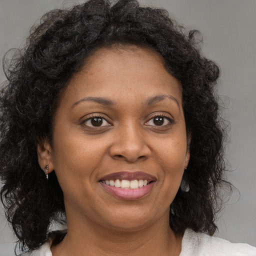 Joyful black young-adult female with medium  brown hair and brown eyes