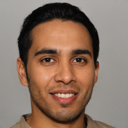 Joyful latino young-adult male with short  brown hair and brown eyes