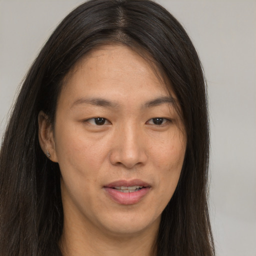 Joyful asian young-adult female with long  brown hair and brown eyes