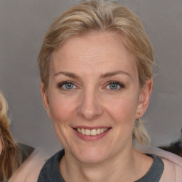 Joyful white adult female with medium  brown hair and blue eyes