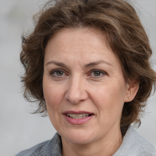 Joyful white adult female with medium  brown hair and grey eyes