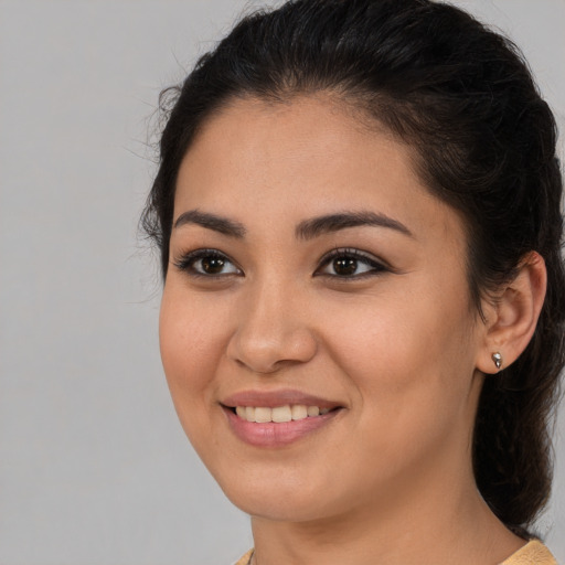 Joyful latino young-adult female with medium  brown hair and brown eyes
