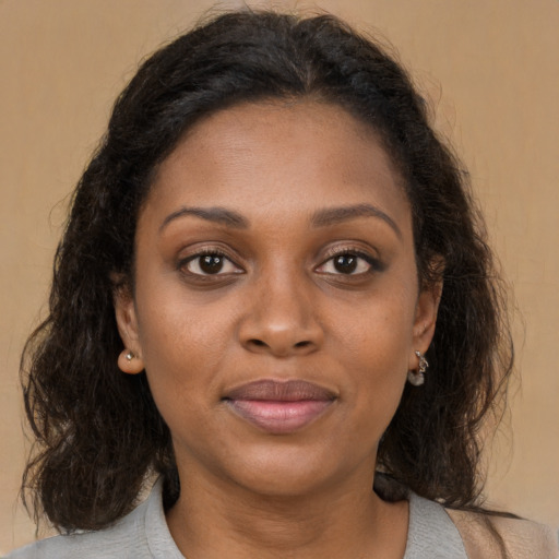 Joyful black adult female with medium  brown hair and brown eyes