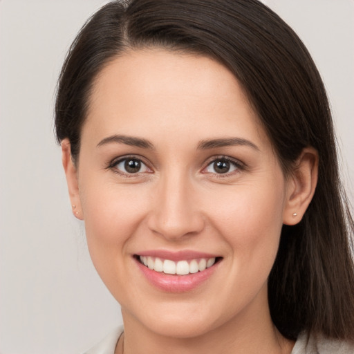 Joyful white young-adult female with long  brown hair and brown eyes