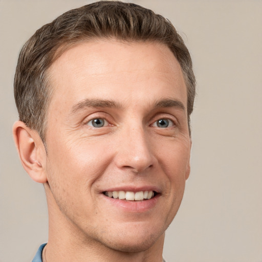 Joyful white adult male with short  brown hair and grey eyes