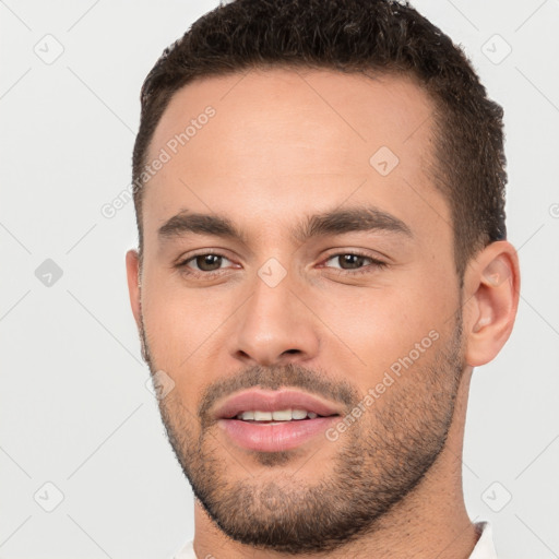 Joyful white young-adult male with short  brown hair and brown eyes