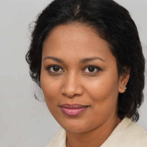 Joyful black adult female with medium  brown hair and brown eyes