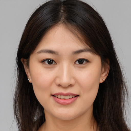 Joyful asian young-adult female with long  brown hair and brown eyes