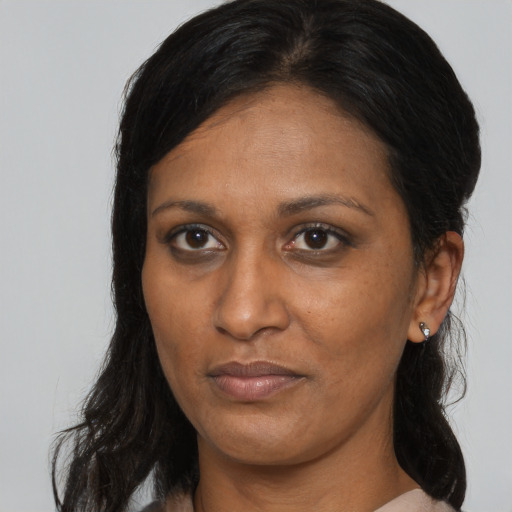 Neutral latino adult female with long  brown hair and brown eyes