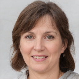 Joyful white adult female with medium  brown hair and grey eyes