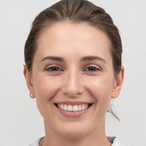 Joyful white young-adult female with short  brown hair and grey eyes