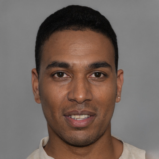 Joyful black young-adult male with short  black hair and brown eyes